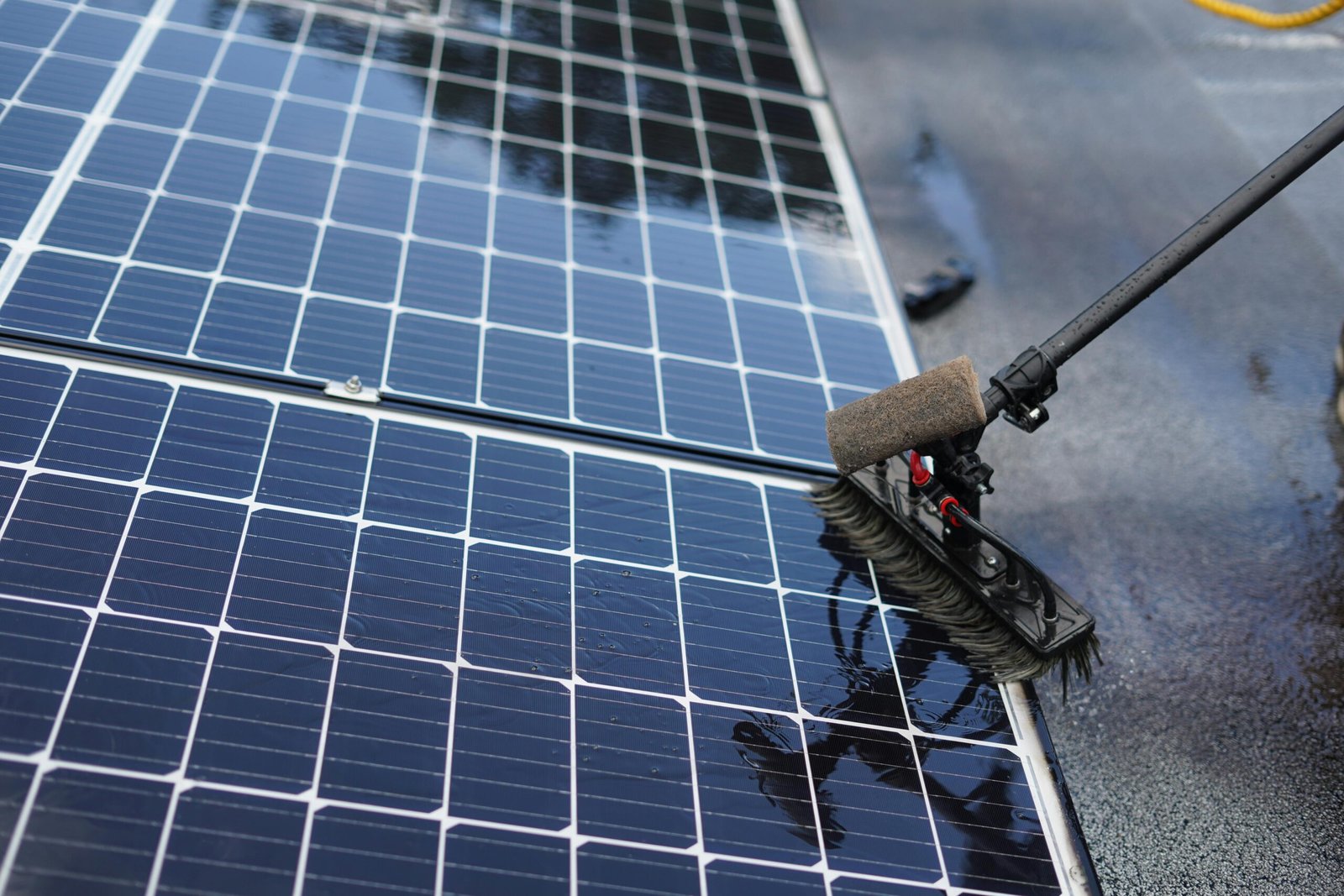 Close-up of solar panel cleaning using a brush tool in Tampa, Florida.
